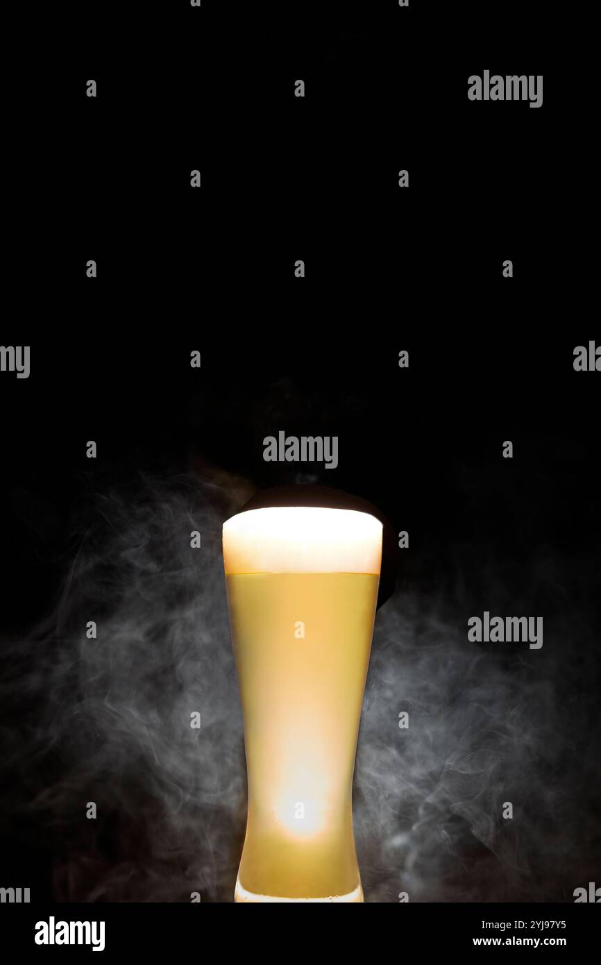 Bier und Rauch auf schwarzem Hintergrund Stockfoto