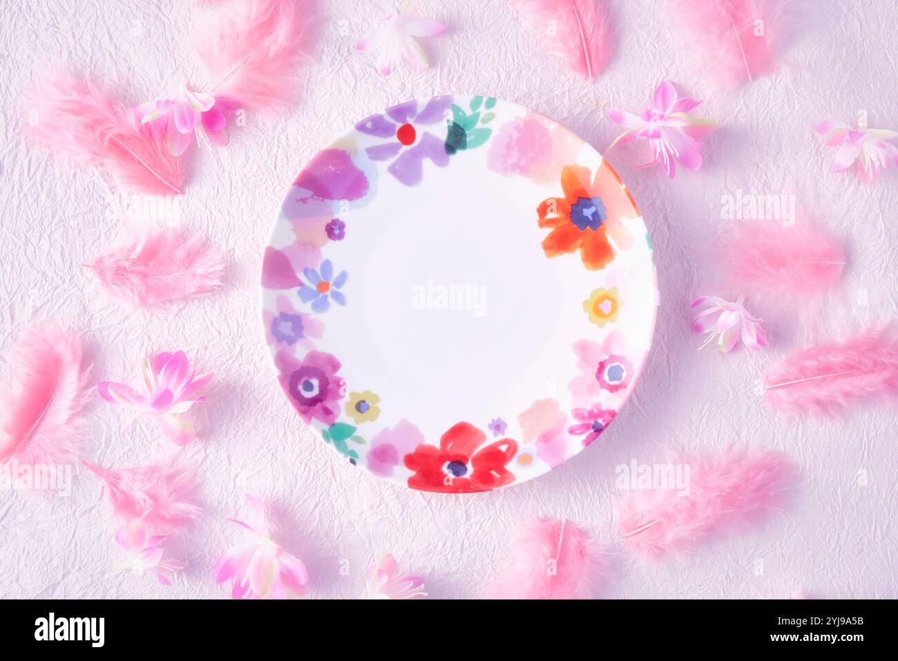 Blumenschale auf rosafarbenem Washi-Papier mit rosa Federn und Blumen Stockfoto