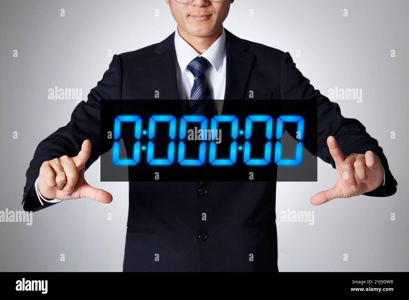 Geschäftsmann, der ein Hologramm einer Digitaluhr mit beiden Händen umgibt Stockfoto