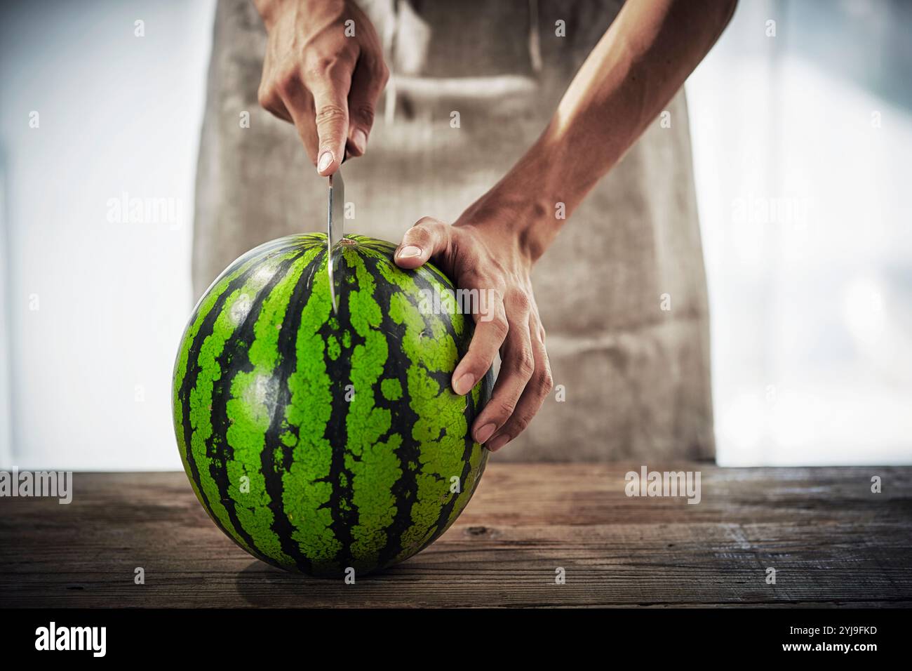 Wassermelonenschneider in der Hand Stockfoto