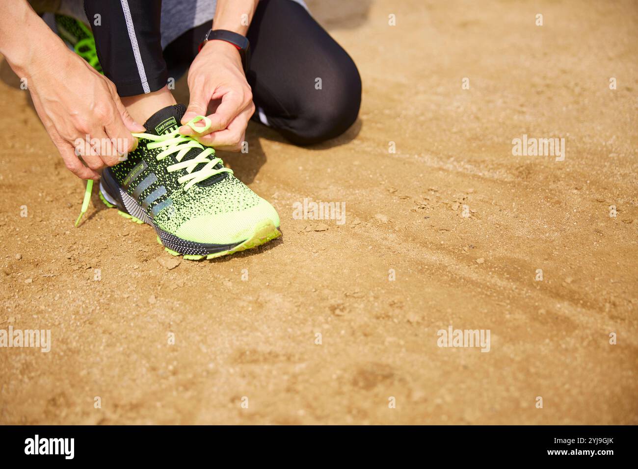 Der Sportler bindet seine Schnürsenkel auf dem Spielfeld Stockfoto