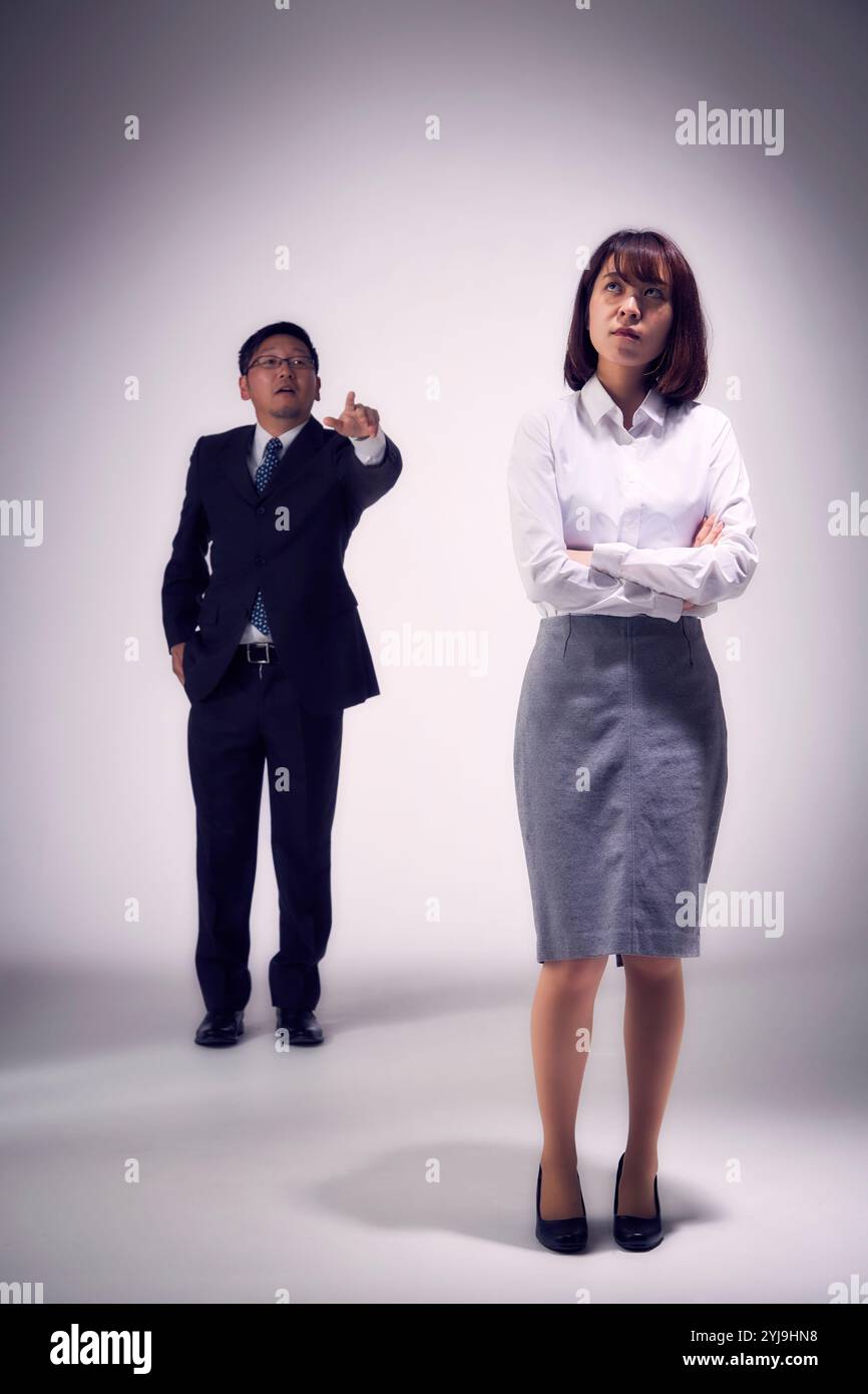 Weibliche Angestellte ignoriert die Predigt ihres Bosses Stockfoto