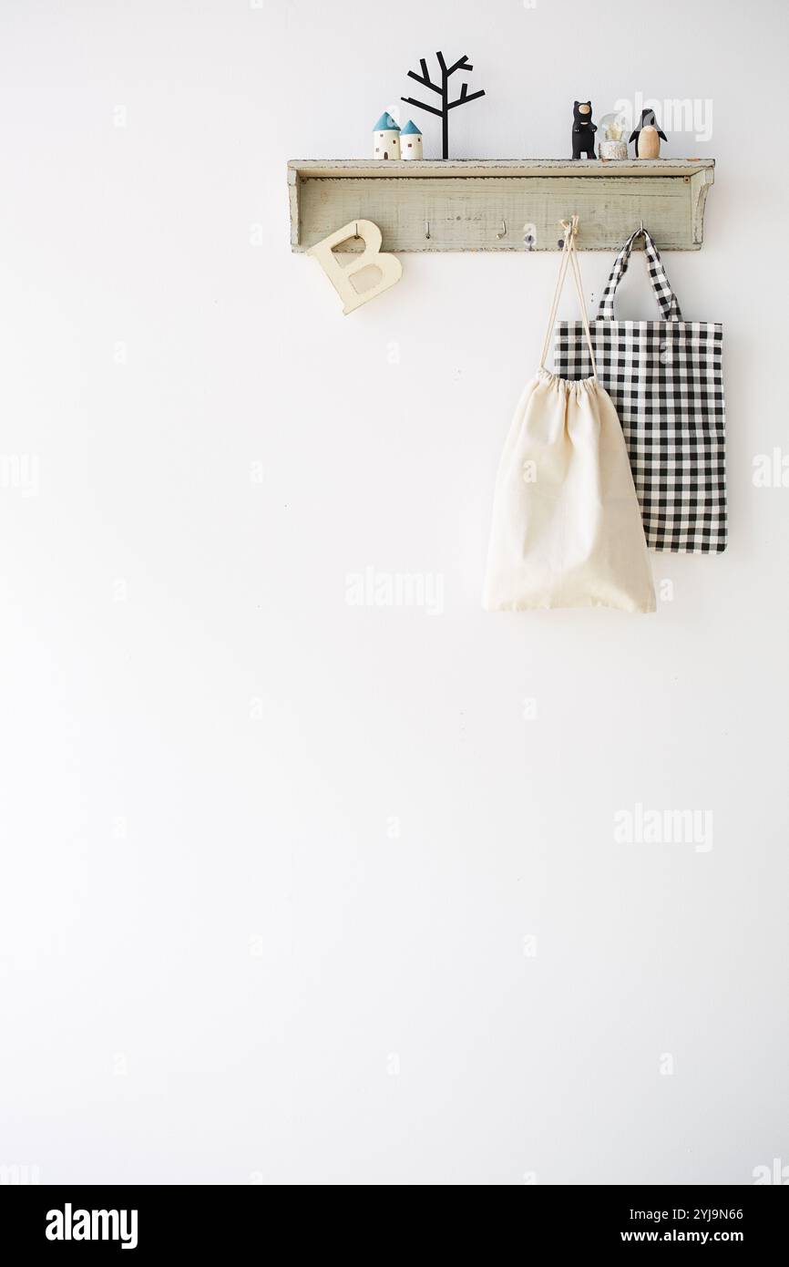 Regal mit Taschenhaken an der weißen Wand Stockfoto