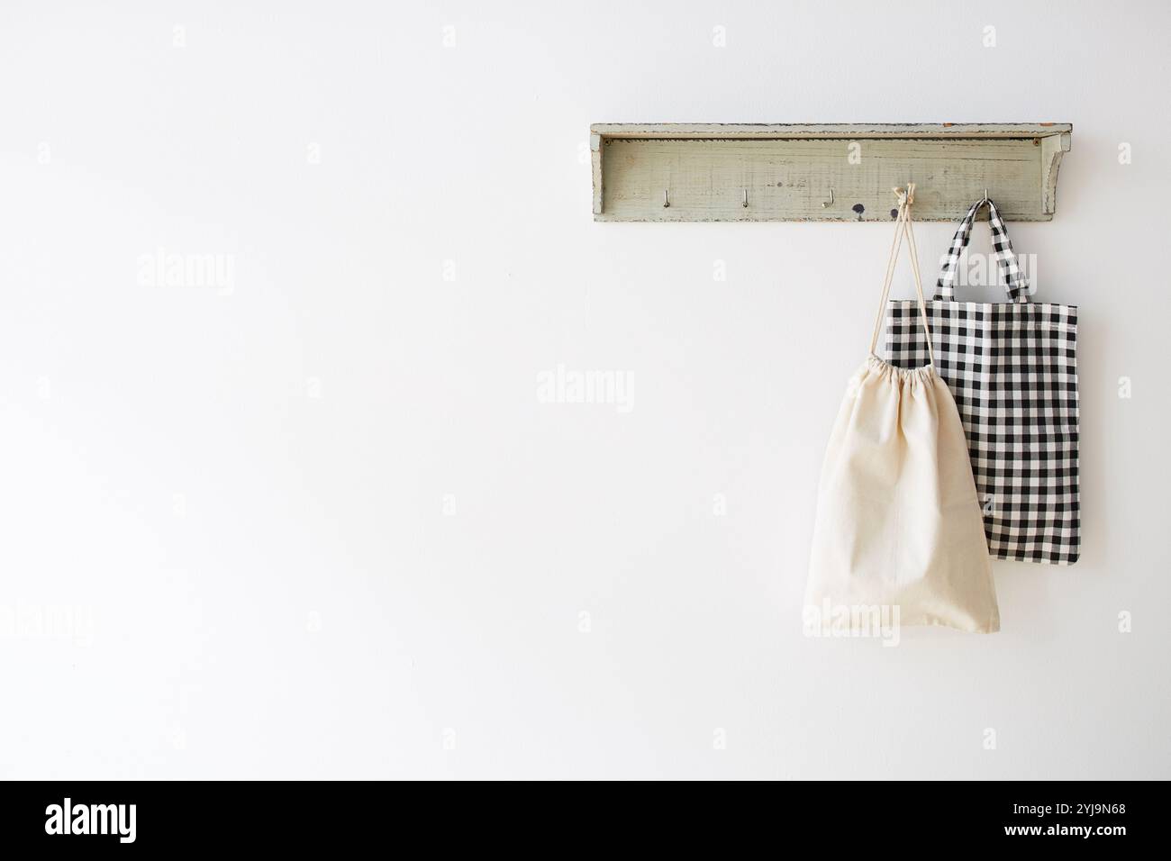 Regal mit Taschenhaken an der weißen Wand Stockfoto