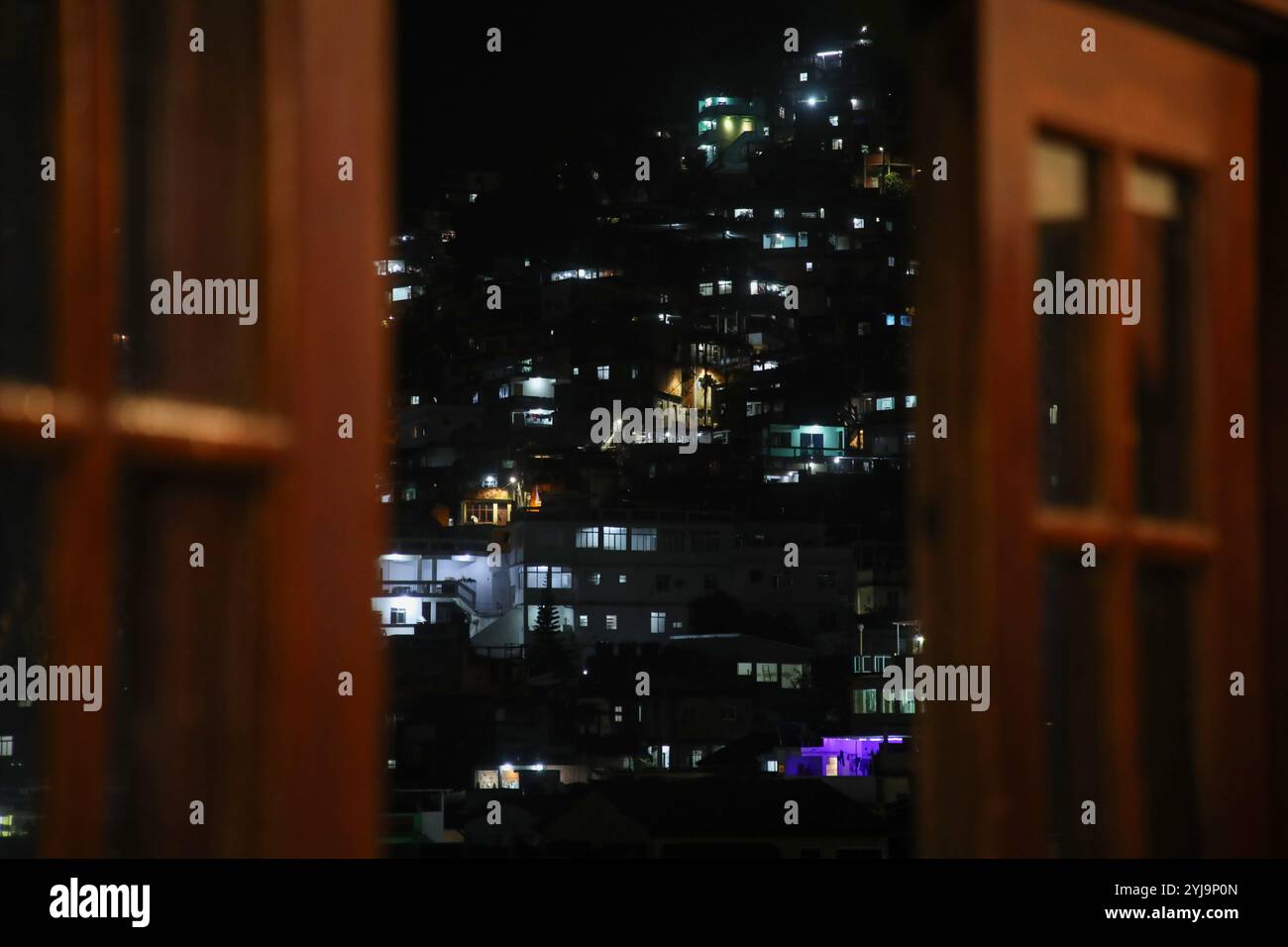 Aus dem Fenster der Nos do Morro Theaterschule wird Vidigals Favela nachts gesehen. In den Favelas von Rio de Janeiro, Brasilien, ist seit den späten 2000er Jahren eine Generation junger Regisseurinnen entstanden Ihr Ziel ist es, alternative Narrative zu produzieren, weit entfernt von den Klischees des Menschenhandels und der Sexualisierung von Frauen. Stockfoto