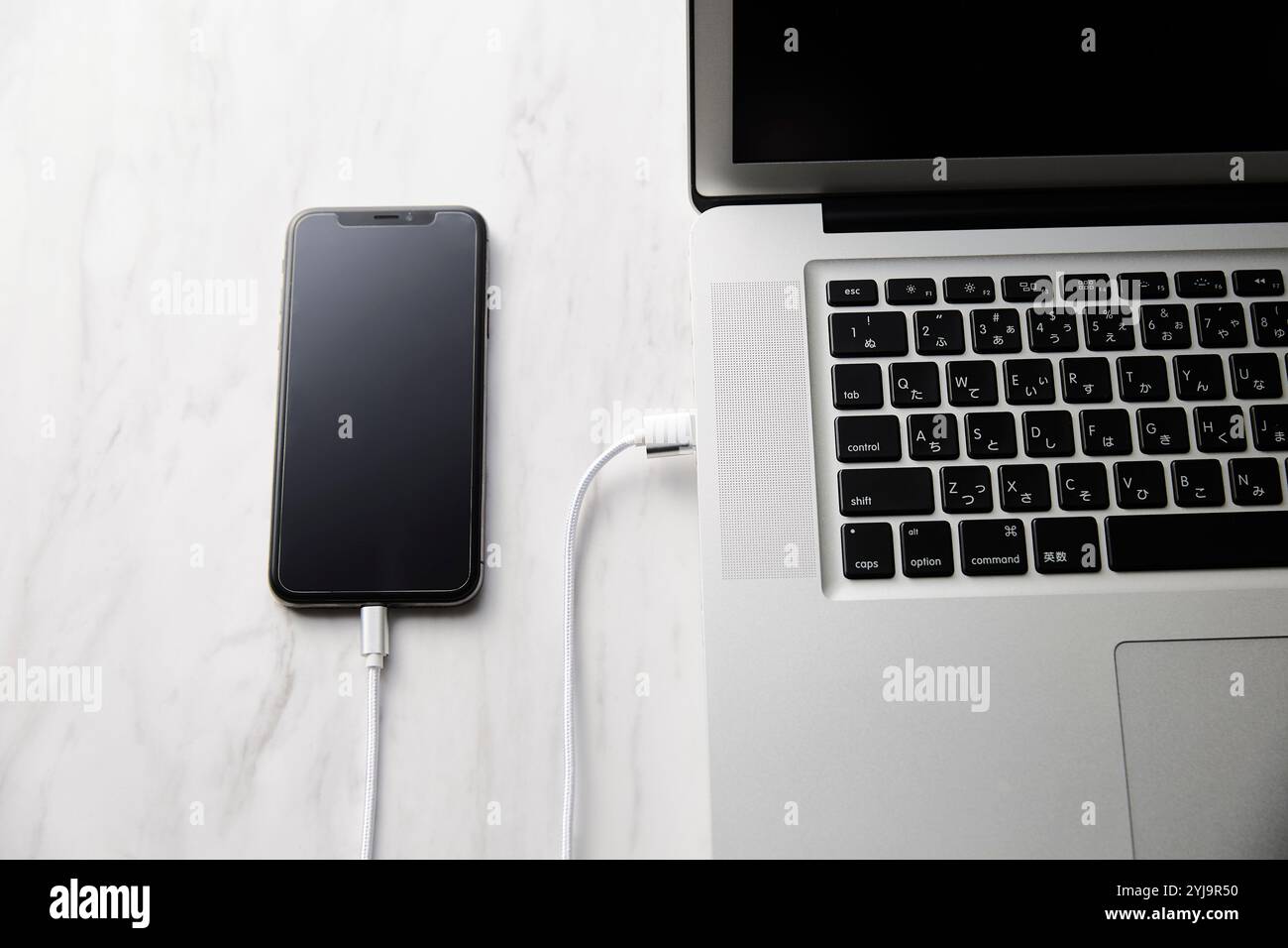 Laptop und Smartphone auf einem Tisch mit Marmorplatte Stockfoto