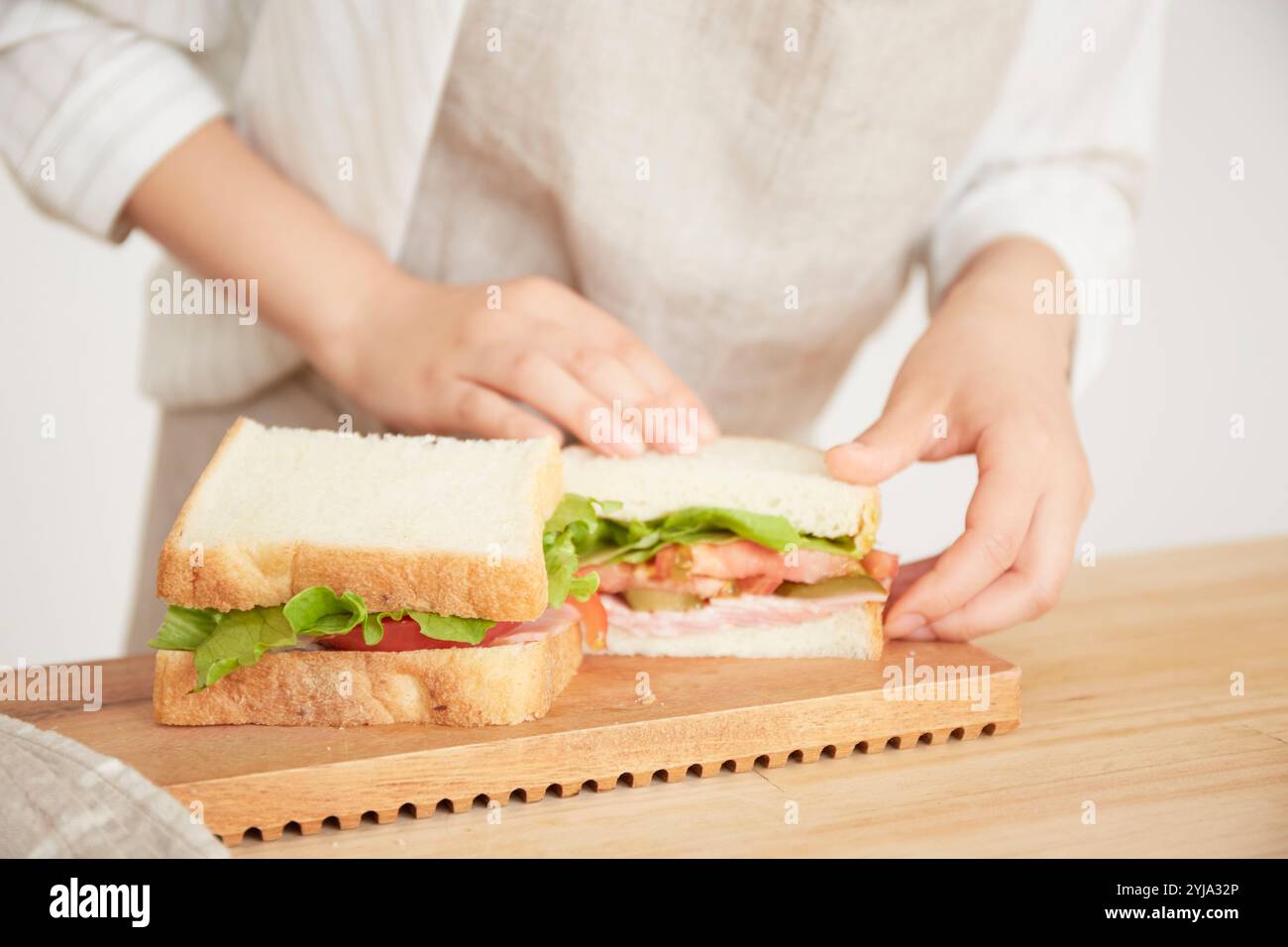 Frau, die ein zerschnittenes Sandwich öffnet Stockfoto