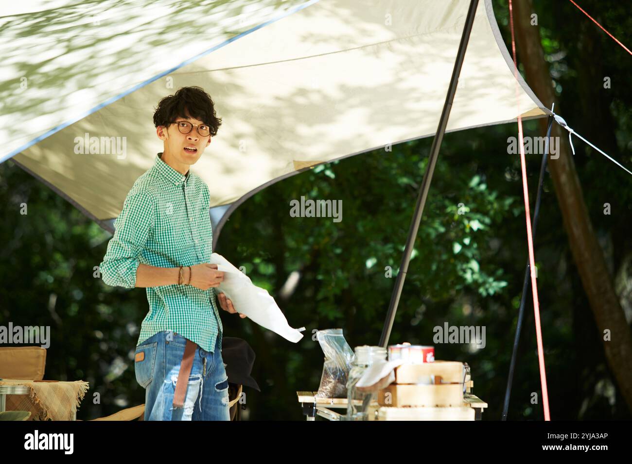 Mann hält Plastiktüte unter Plane Stockfoto