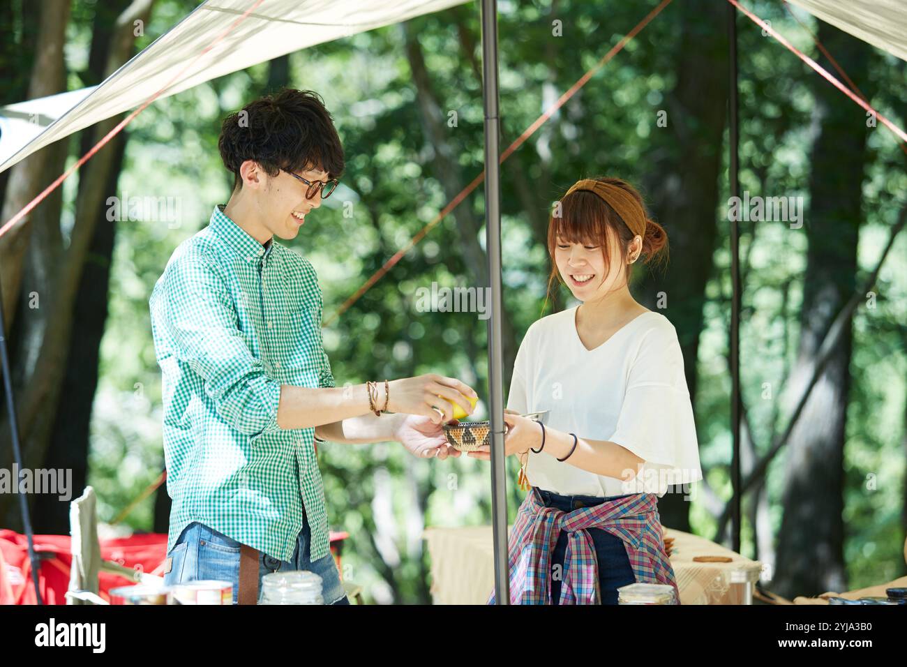 Mann und Frau kochen zusammen unter einer Plane. Stockfoto
