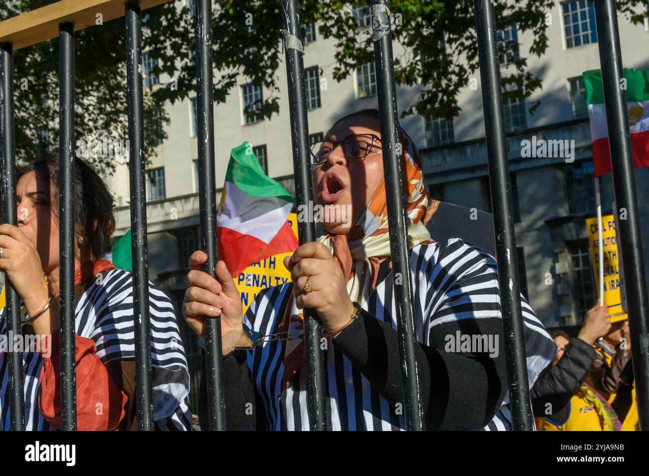 London, Großbritannien. Oktober 2018. Frauen in Prionenkleidung stehen hinter Gefängnisgittern beim Protest. Hinter dem Banner "Demokratie im Iran mit Maryam Rajavi" protestierten die iranischen Volksmudschaheddin gegen das repressive gegenwärtige Regime im Iran, mit einem Gibbet und drei Frauen in einer Gefängniszelle, die die Herrschaft des Terrors dort illustrieren und ein Ende der Hinrichtungen dort forderten. Plakate erinnerten uns daran, dass das iranische Regime der Weltrekordhalter für Hinrichtungen ist. Rajavi, der Vorsitzende der PMOI, hat ein 10-Punkte-Manifest vorgelegt, in dem ein modernes Rechtssystem, die Gleichstellung der Geschlechter und das politische usw. gefordert werden Stockfoto