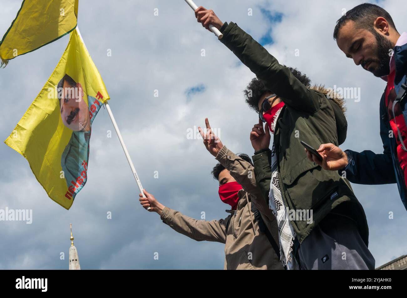 London, Großbritannien. Mai 2018. Kurden halten Flaggen, die Ocalan und die YPG-Verteidigungsstreitkräfte unterstützen, auf einem der Löwen auf dem Trafalgar Square bei der Kundgebung, darunter viele von Londons internationalen und Migrantengemeinschaften, die den Internationalen Arbeitertag feiern. Einige Gewerkschafter und Aktivisten hielten Reden und schlossen ein kurzes Schweigen zum Gedenken an Mehmet Aksoy ein, der in Syrien während der Dreharbeiten mit kurdischen Kämpfern getötet wurde und bei früheren Ereignissen für die Kurden gesprochen hatte. Am Ende der Kundgebung gab es eine Rede von Brixton ritzy Gewerkschafterin Kelly Rogers, die von Picturehouse und The V zum Opfer fiel Stockfoto