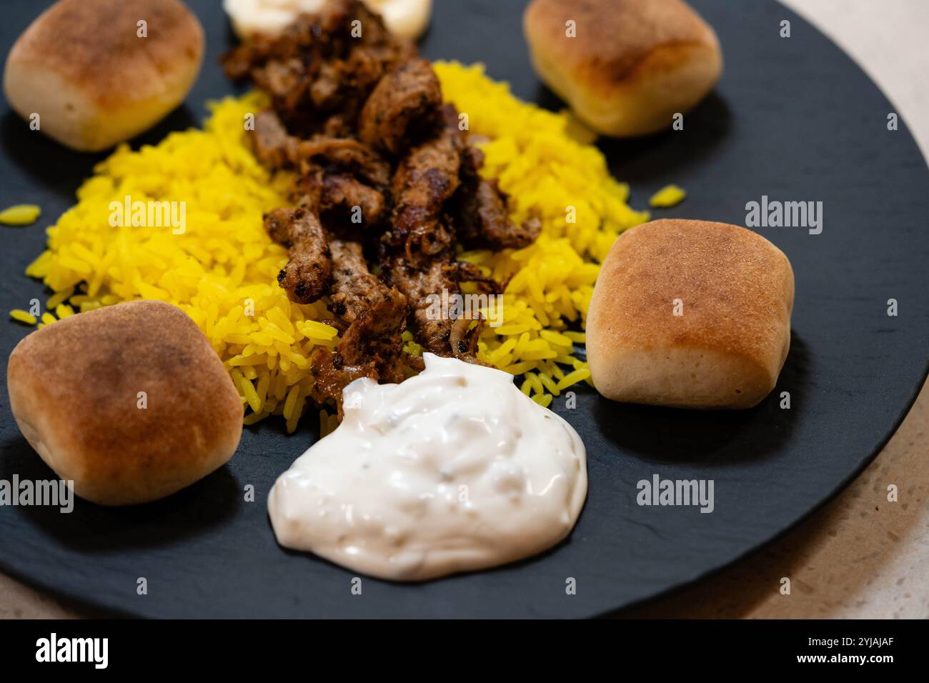 Gebratene Gyros mit hausgemachten Tzatziki und griechischen Gewürzen Stockfoto