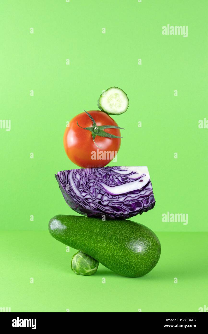 Gleichgewicht schwimmende Nahrung Gleichgewicht von Avocado, Purpurkohl auf grünem Hintergrund. Stockfoto
