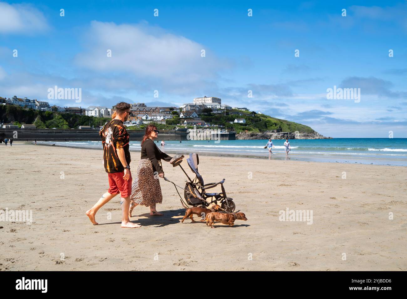 Eine Familie im Urlaub macht einen Spaziergang über den Strand von Towan bei Ebbe in Newquay in Cornwall in Großbritannien. Stockfoto