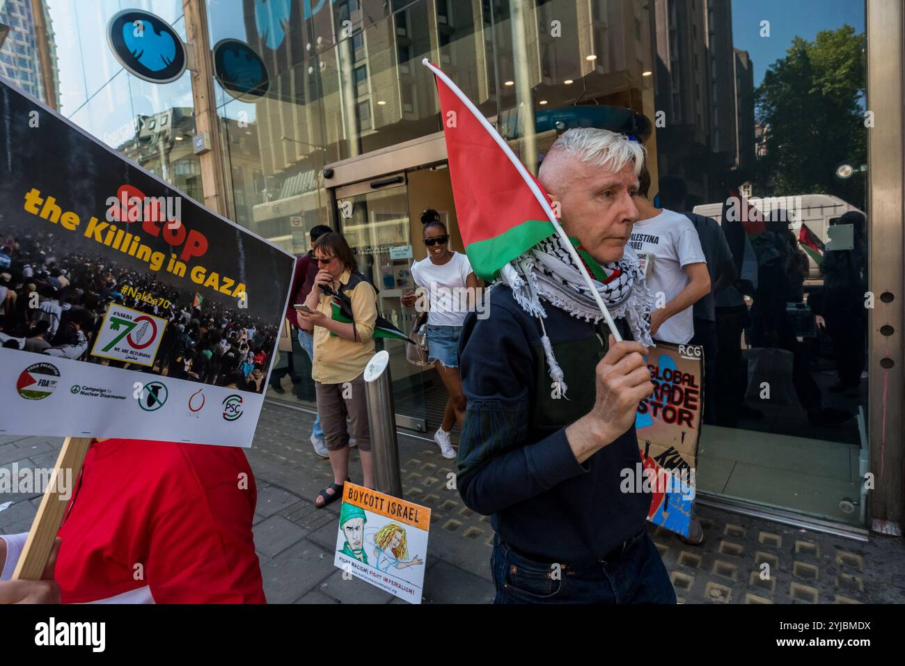 London, Großbritannien. Mai 2018. Demonstranten der Revolutionären Kommunistischen Gruppe und des Sieges der Intifada fordern ein Ende der gesamten britischen Unterstützung für Israel nach dem barbarischen Massaker der israelischen Scharfschützen an unbewaffneten Demonstranten, die am Großen Rückkehrmarsch im Gazastreifen teilgenommen haben, bei dem über 60 Menschen getötet und Tausende schwer verletzt wurden. Viele der Waffen, mit denen die Demonstranten getötet wurden, wurden vermutlich von britischen Rüstungsunternehmen geliefert. Der Protest begann vor einer Filiale der Barclays Bank, die große Investitionen in Israel getätigt hat, und setzte sich weiter in der Oxford Street fort, wobei er kurz anhalten musste, um außerhalb der USA zu sprechen und zu protestieren Stockfoto