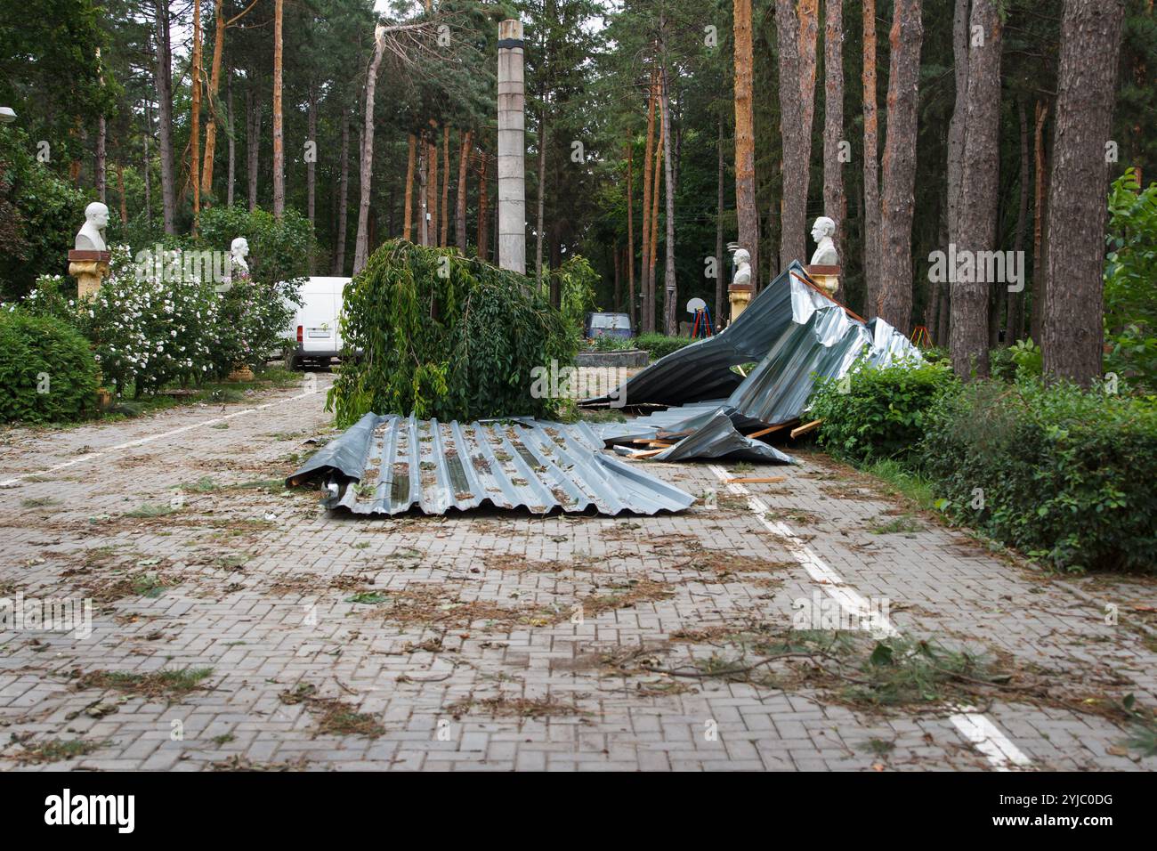 Der Metallzaun wird durch einen starken Hurrikanwind gebeult und gebogen. Folgen von Naturkatastrophen, die das Parkgelände getroffen haben, Hintergrund Stockfoto