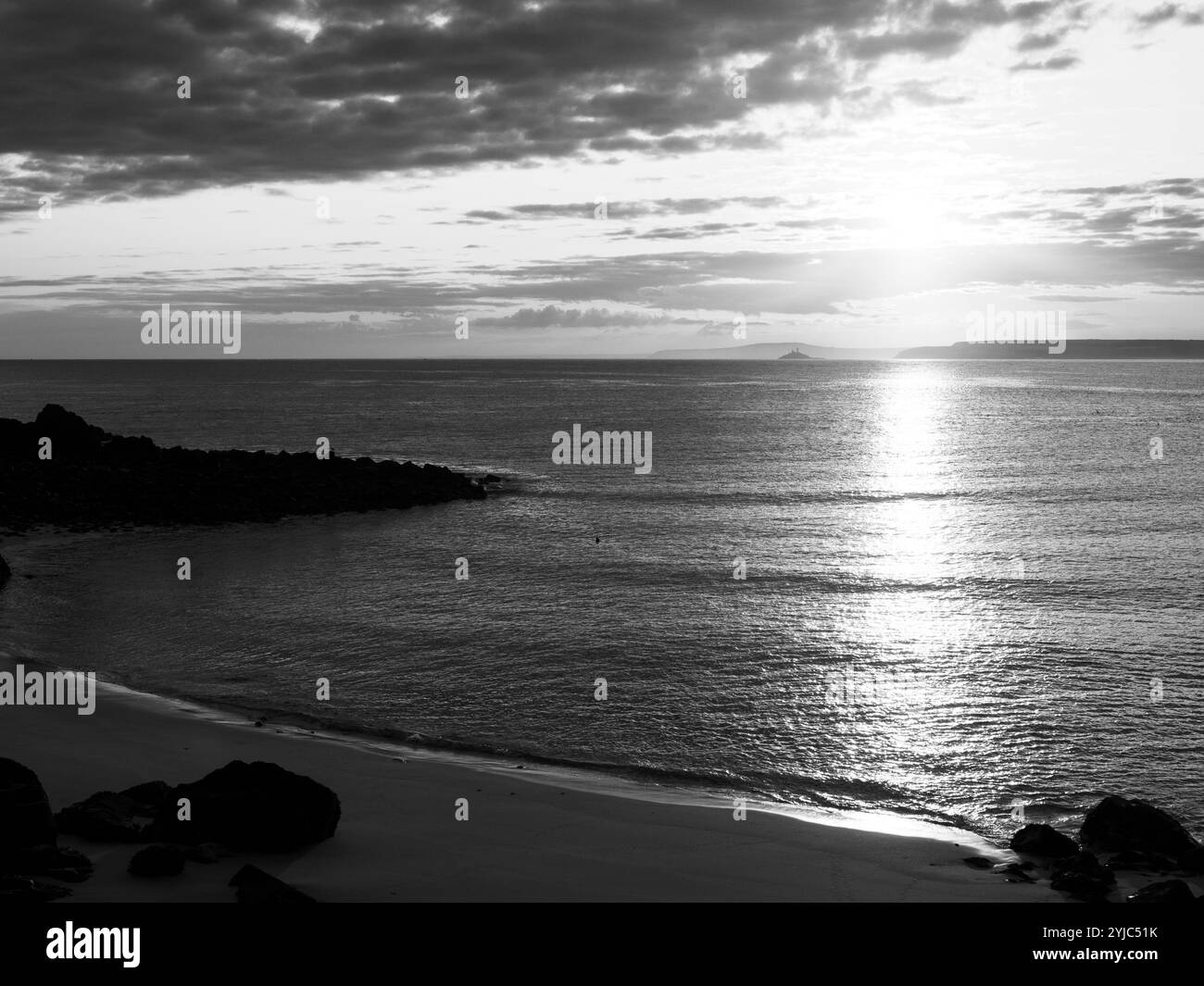 S&W Landscape, Porthgwidden Beach, Sunrise, Godrevy Lighthouse (weit entfernt), auf Rocky Island, St Ives, Cornwall, England, GROSSBRITANNIEN, GB. Stockfoto