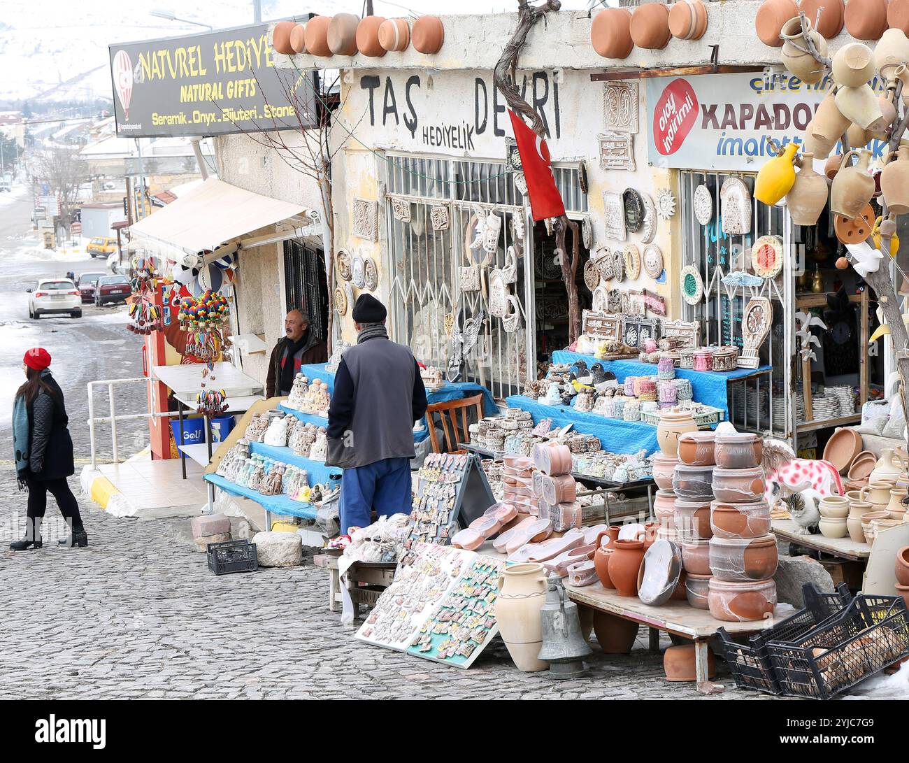 UCHISAR, NEVSEHIR, TÜRKEI-04.FEBRUAR 2017: Unbekannte weibliche Kundin verlässt Souvenirshop mit farbenfrohen Töpfereien Stockfoto