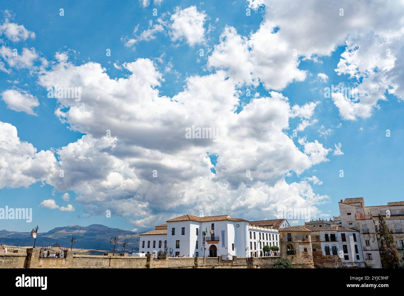 Helle weiße Gebäude von Ronda heben sich von einem leuchtend blauen Himmel ab Stockfoto