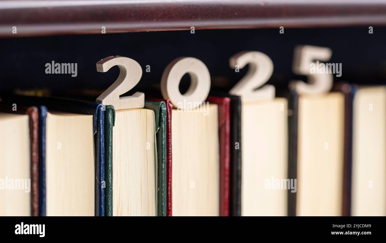 número 2025 de madera sobre libros de una estantería de una biblioteca Stockfoto