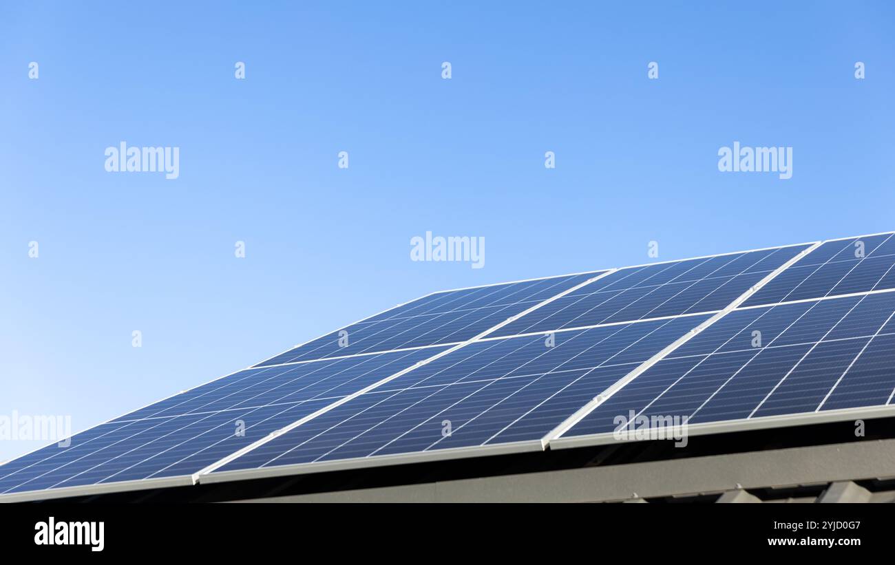 Luftaufnahme von Solarzellen auf klarem blauem Himmelhintergrund. Sauberes Konzept für alternative Energie, nachhaltige Ressourcen. Modernes Haus, Solarscheibe Stockfoto