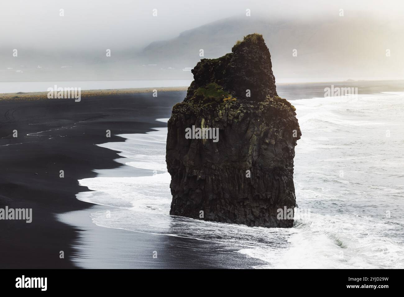 Detail des Arnardrangur-Felsens in der Mitte der Halbinsel in der Nähe von Reynisfjara Beach Aussichtspunkt Dyrholaey bei bewölktem Wetter. Stockfoto