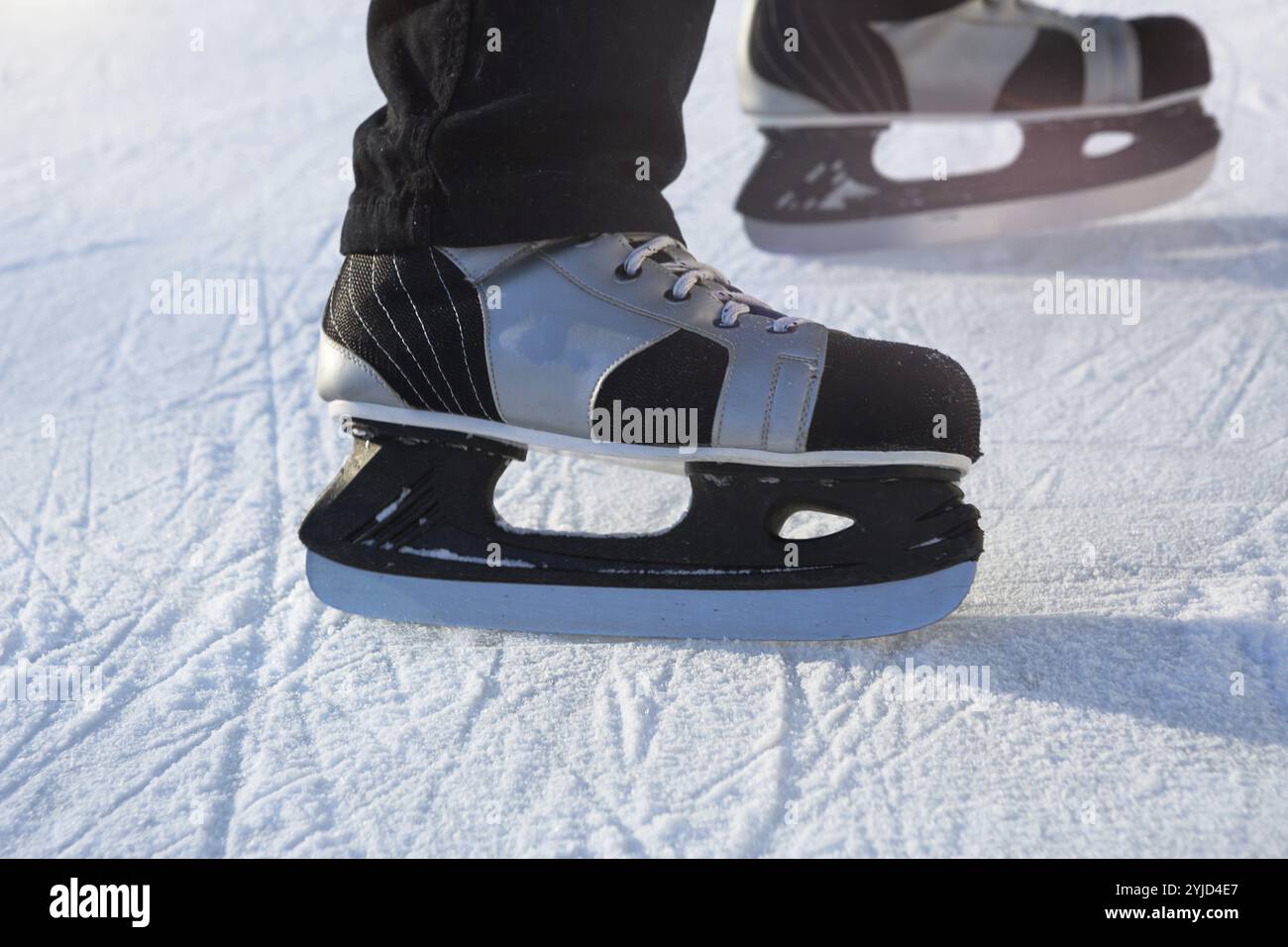 Schlittschuhlaufen für Erwachsene Männer – Nahaufnahme des Eislaufs im Winter unterwegs. Rollen und Rutschen an frostigen sonnigen Tagen, aktiver Wintersport und Lifestyle Stockfoto