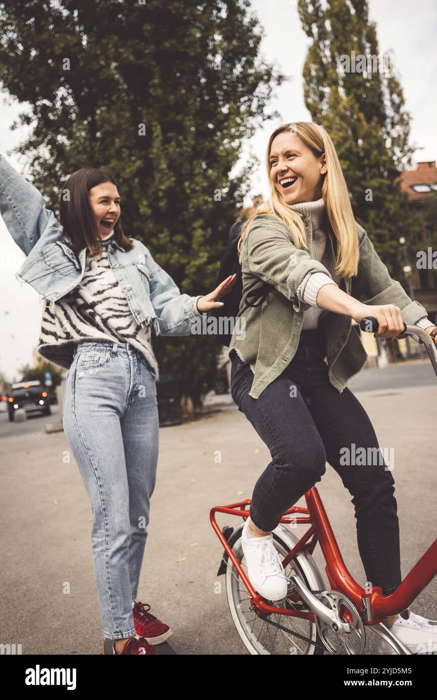 Zwei junge kaukasische Frauen, die Spaß auf der Stadtstraße im Freien haben, beste Freunde, die einen gemeinsamen Feiertag genießen, fröhlicher Lebensstil, Jugendliche und junge Frauen Stockfoto