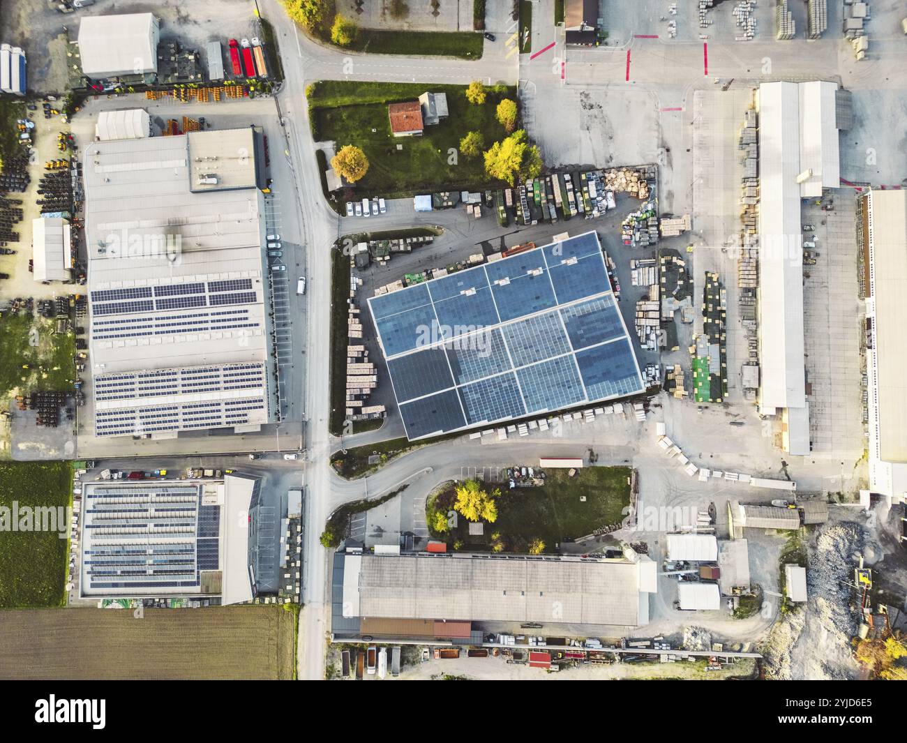 Aus der Vogelperspektive einer Fabrik, einer Lagerhalle in den Vororten mit Dach, das mit Solarpaneelen bedeckt ist. Stockfoto