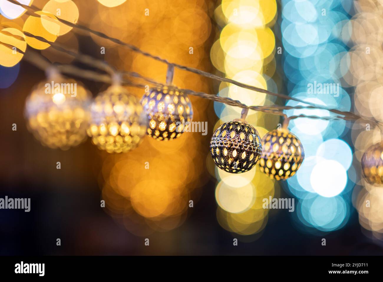 LED-Leuchten mit Metallschnur hängen im Freien zur Dekoration bei Weihnachtsfeiern in der Nacht in der Stadt Stockfoto