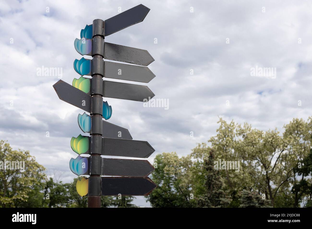 Mehrere leere Schilder mit Blinkleuchten gegen bewölkten Himmel. Platz für Text. Horizontal. Indikatoren der Bewegung zum Ziel für Touristen Stockfoto