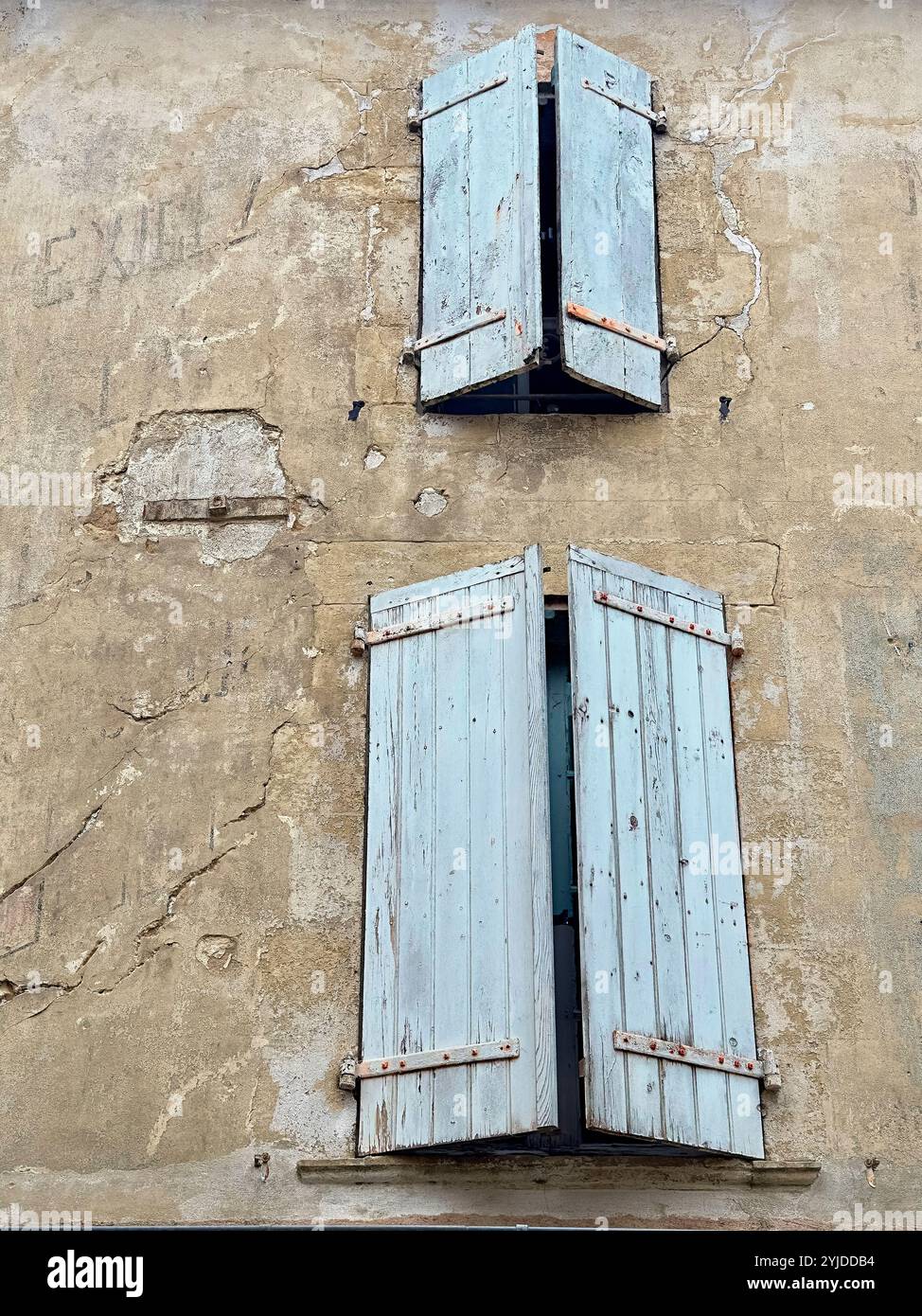Blau verwitterte Holzläden an rissiger Gebäudefassade, Dordogne, Frankreich Stockfoto