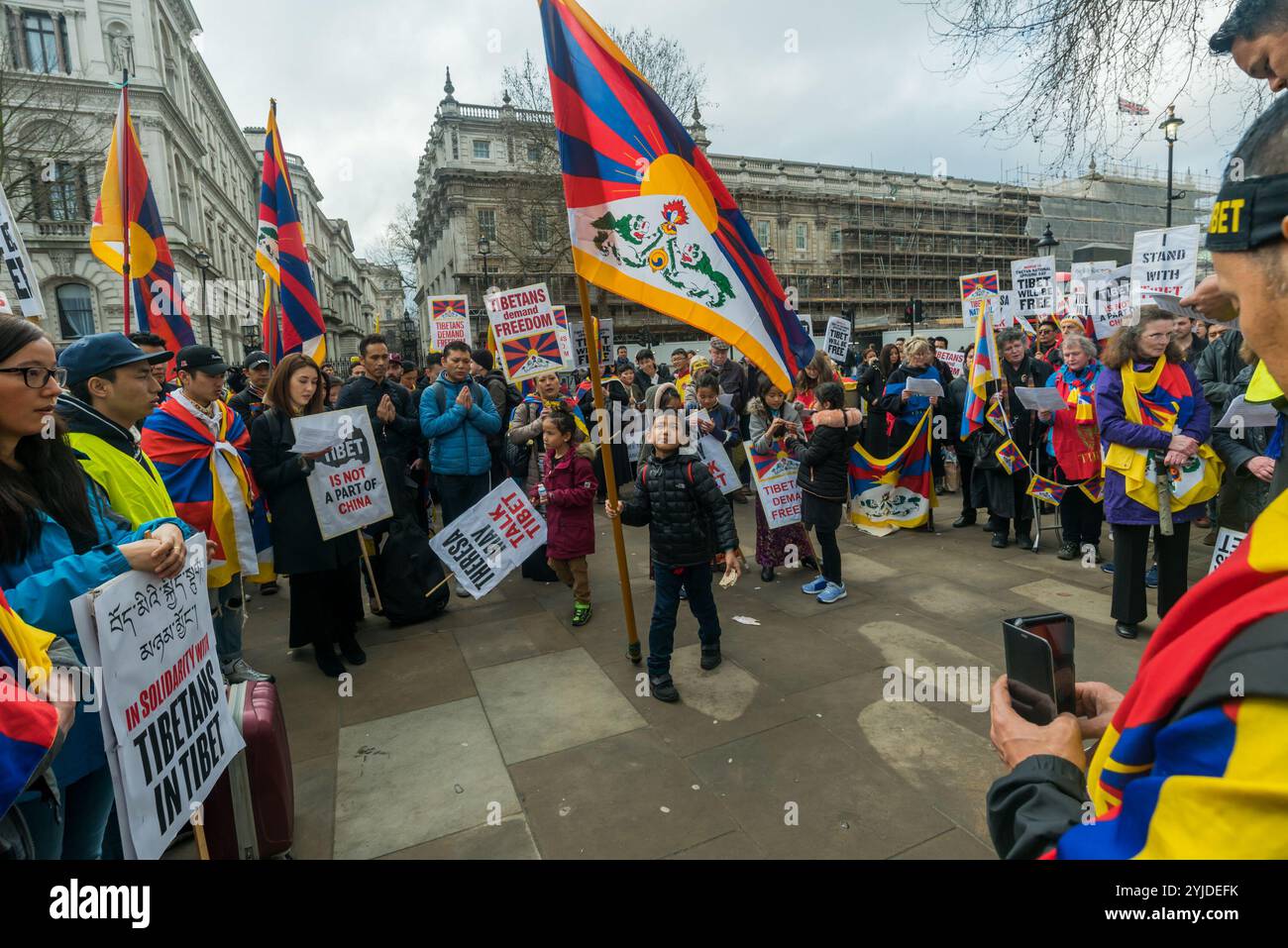 London, Großbritannien. März 2018. Die Menschen beten bei der Kundgebung vor dem jährlichen Tibet-freiheitsmarsch in London, der dem 59. Jahrestag des tibetischen Nationalaufstandes gedenkt. Mehrere Hunderte von Menschen, darunter viele Tibeter und Unterstützer, versammeln sich in der Downing St, bevor sie zu einem Protest vor der chinesischen Botschaft marschieren. Bevor der marsch verließ, gab es eine Schweigeminute für die Toten, einschließlich durch Selbstverbrennung, und ein langes tibetisches Gebet, gefolgt vom Singen der tibetischen Nationalhymne. Stockfoto