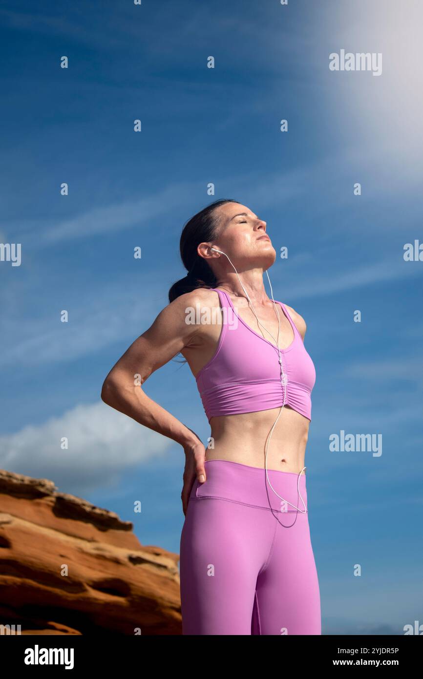 Sportliche Frau, die die Sonne genießt, sich nach dem Training ausruht und Vitamin D erhält Stockfoto