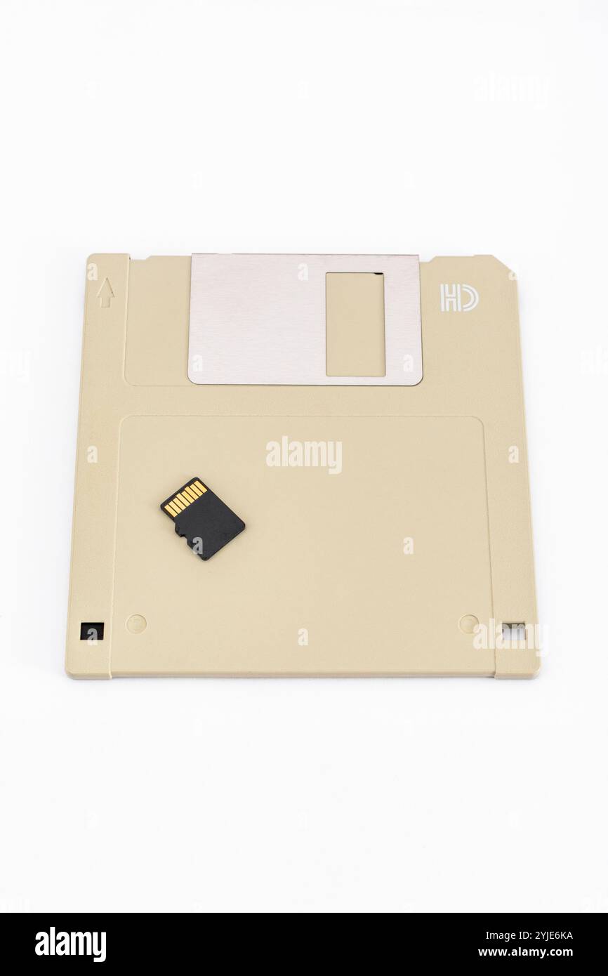 Alte SanDisk 16 GB MicroSD-Karte mit noch älteren 3,5-Zoll-1,4 MB High Density-Diskettenlaufwerken aus dem Zeitalter der Dinosaurier-Heimcomputer. Stockfoto