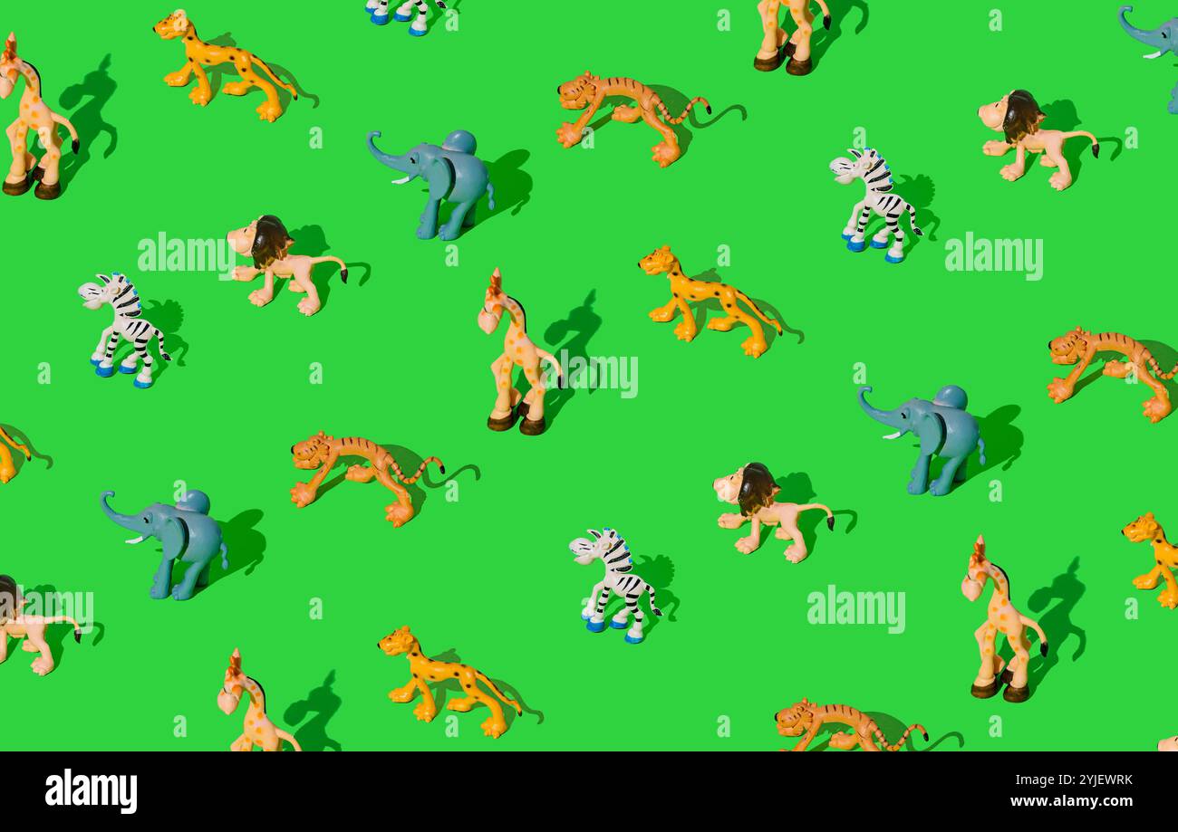 Farbenfrohes Muster aus Tierspielzeug und Figuren auf hellgrünem Hintergrund. Minimales Konzept. Stockfoto