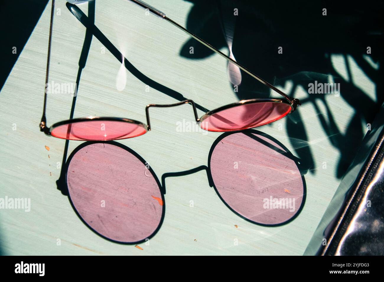 Rose Brille Schatten auf blauem Schreibtisch Stockfoto