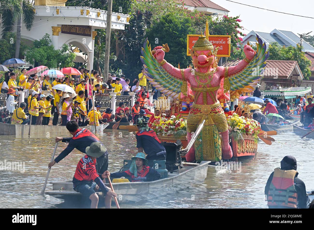 Prozessionsflotte mit großem Garuda-Bild, der auf dem Lotus Throwing Festival in Bang Phli, Samut Prakan, den Samrong-Kanal hinunterfährt Stockfoto