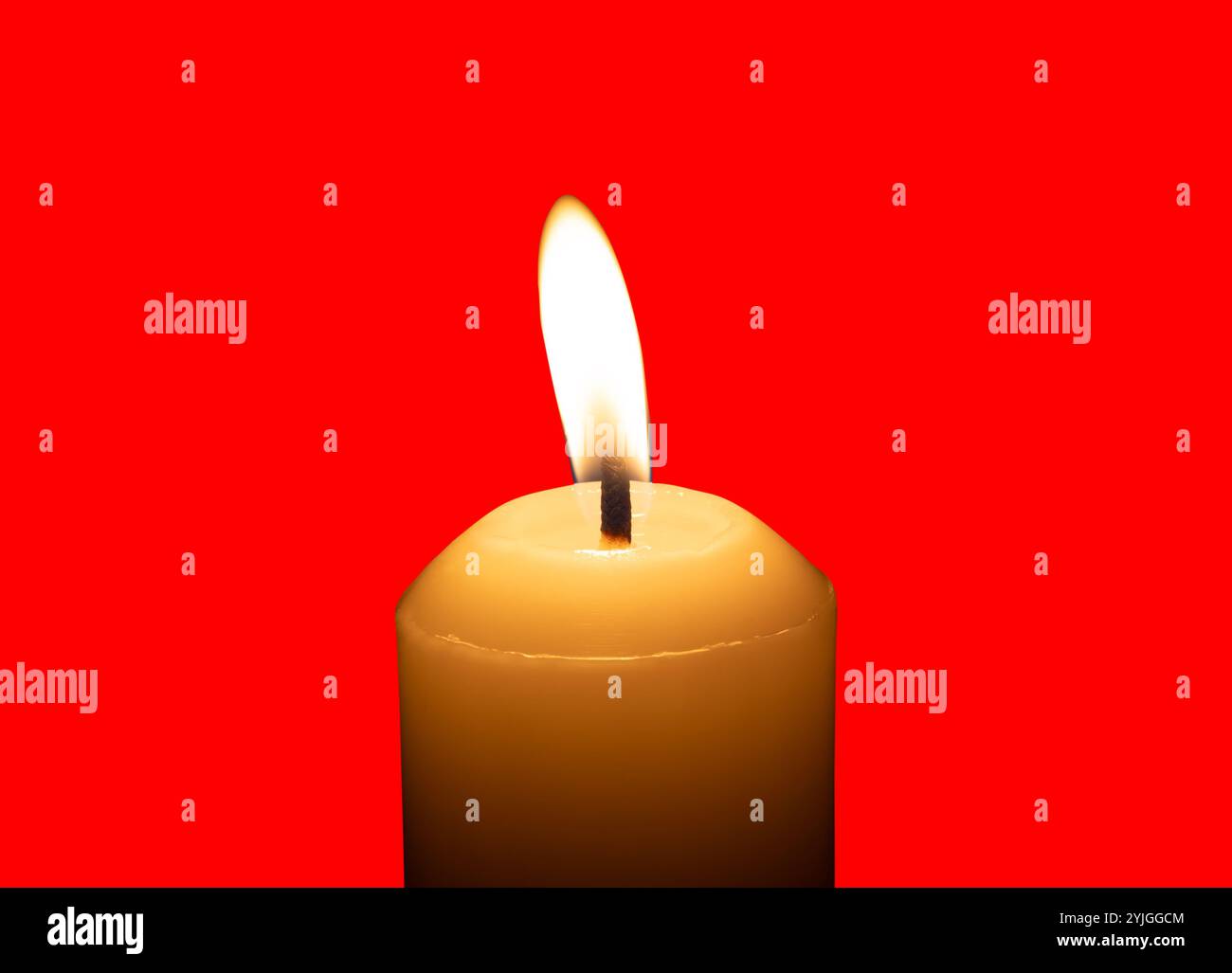 Eine einzelne brennende Kerzenflamme oder ein Licht, das auf einer großen weißen Kerze leuchtet, ist auf rotem Hintergrund mit Beschneidungspfad isoliert. Stockfoto