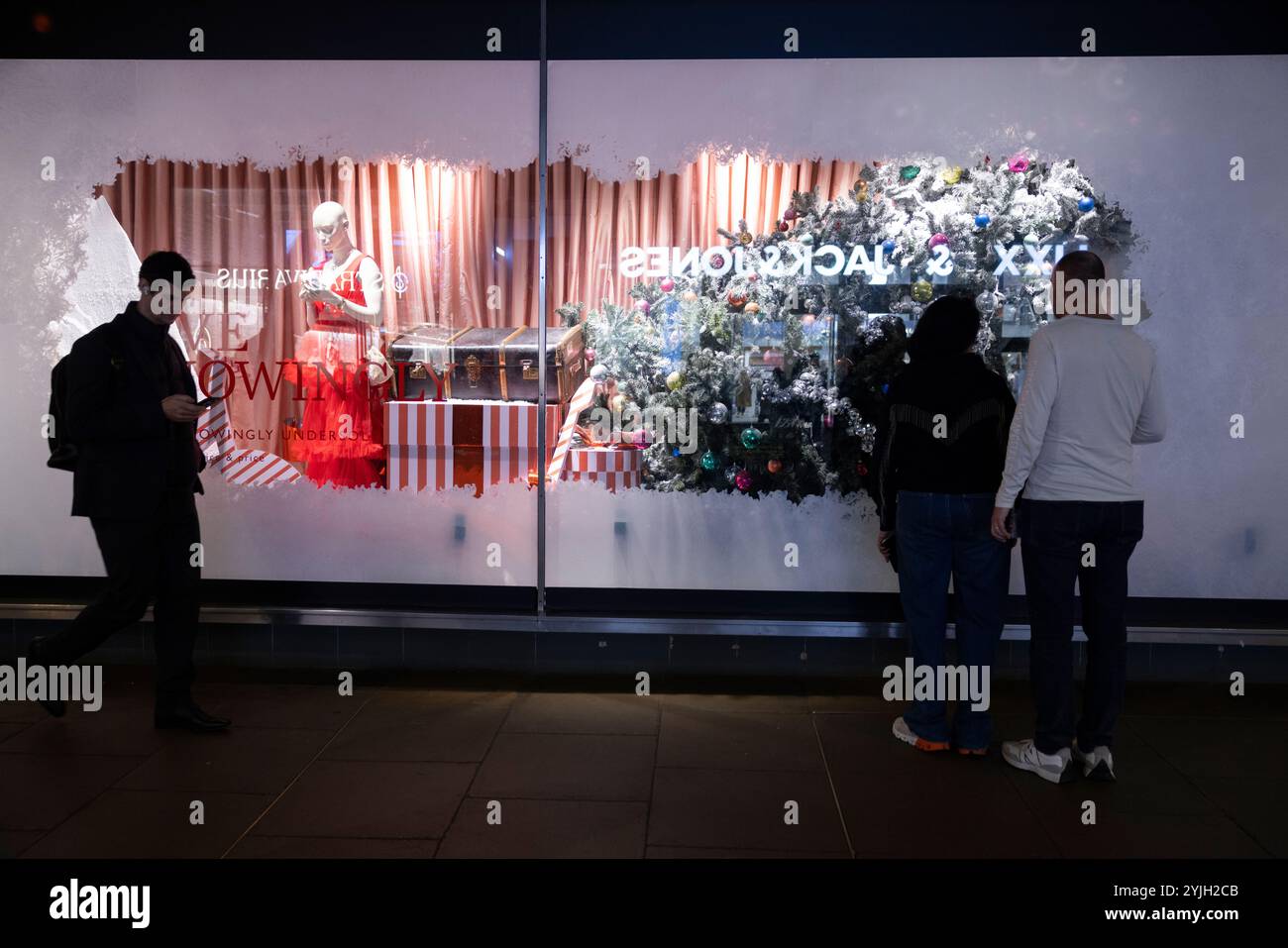 Weihnachtseinkäufer genießen die John Lewis 2024 Weihnachtsfenster zu Beginn der Feiertage entlang der Oxford Street, Großbritanniens geschäftigster Straße. Stockfoto