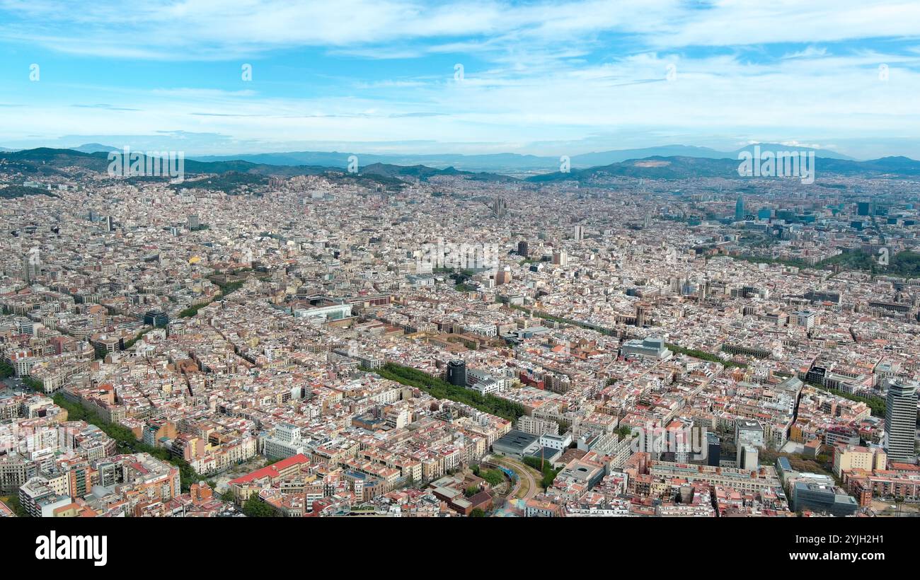 Aus der Vogelperspektive Barcelonas pulsierendes Stadtbild unter einem klaren blauen Himmel, das architektonische Vielfalt und dynamische Zersiedelung zeigt Stockfoto