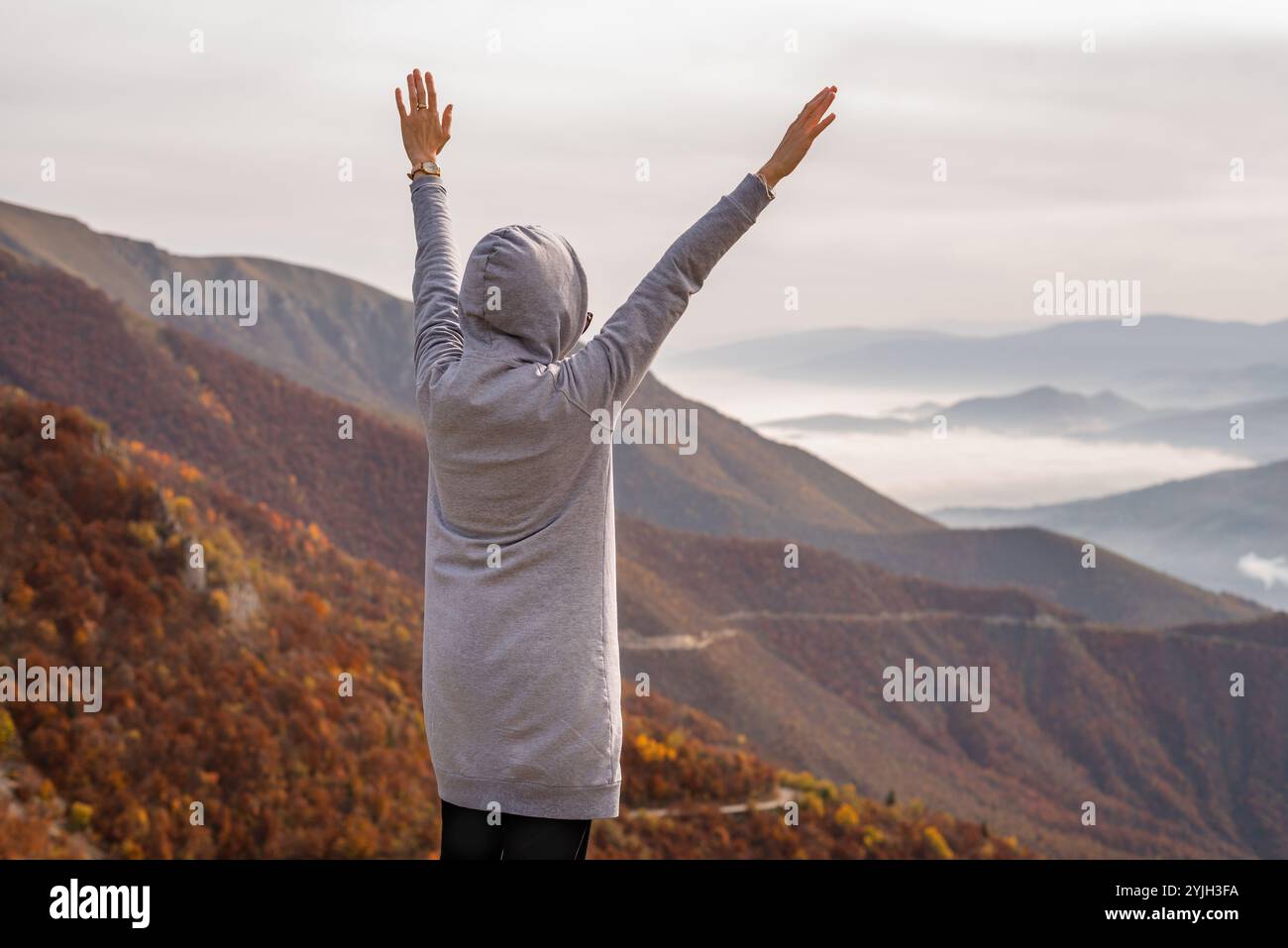 Eine glückliche Frau, die es genießt, Hand auf den Berg zu heben. Der Begriff der freien Freiheit. Stockfoto