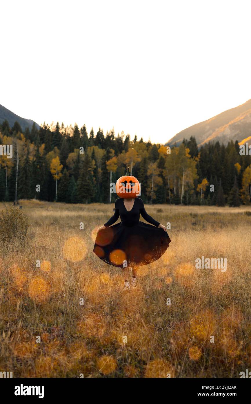 Glückliches Halloween Kürbiskopf Porträt einer Frau im Kleid draußen Stockfoto