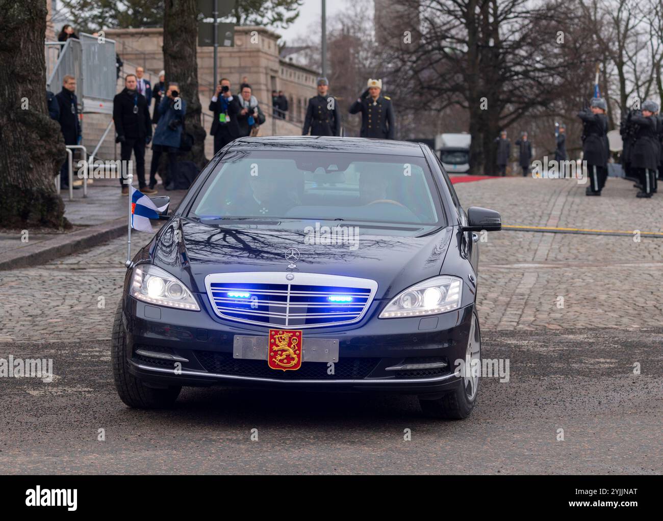 Die früheren und jetzigen Präsidenten Finnlands, Sauli Niinistö und Alexander Stubb, verlassen in ihrer Limousine, während der Verteidigungschef sie grüßt. Stockfoto