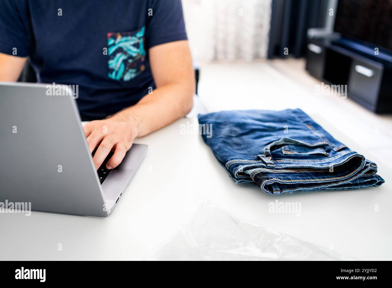 Bringen Sie Kleidung zum Einkaufen zurück. Produktpaket wird zurückgesendet. Jeans in falscher Größe aus dem Onlineshop. Fehler bei der Bestellung von Textilwaren. Stockfoto