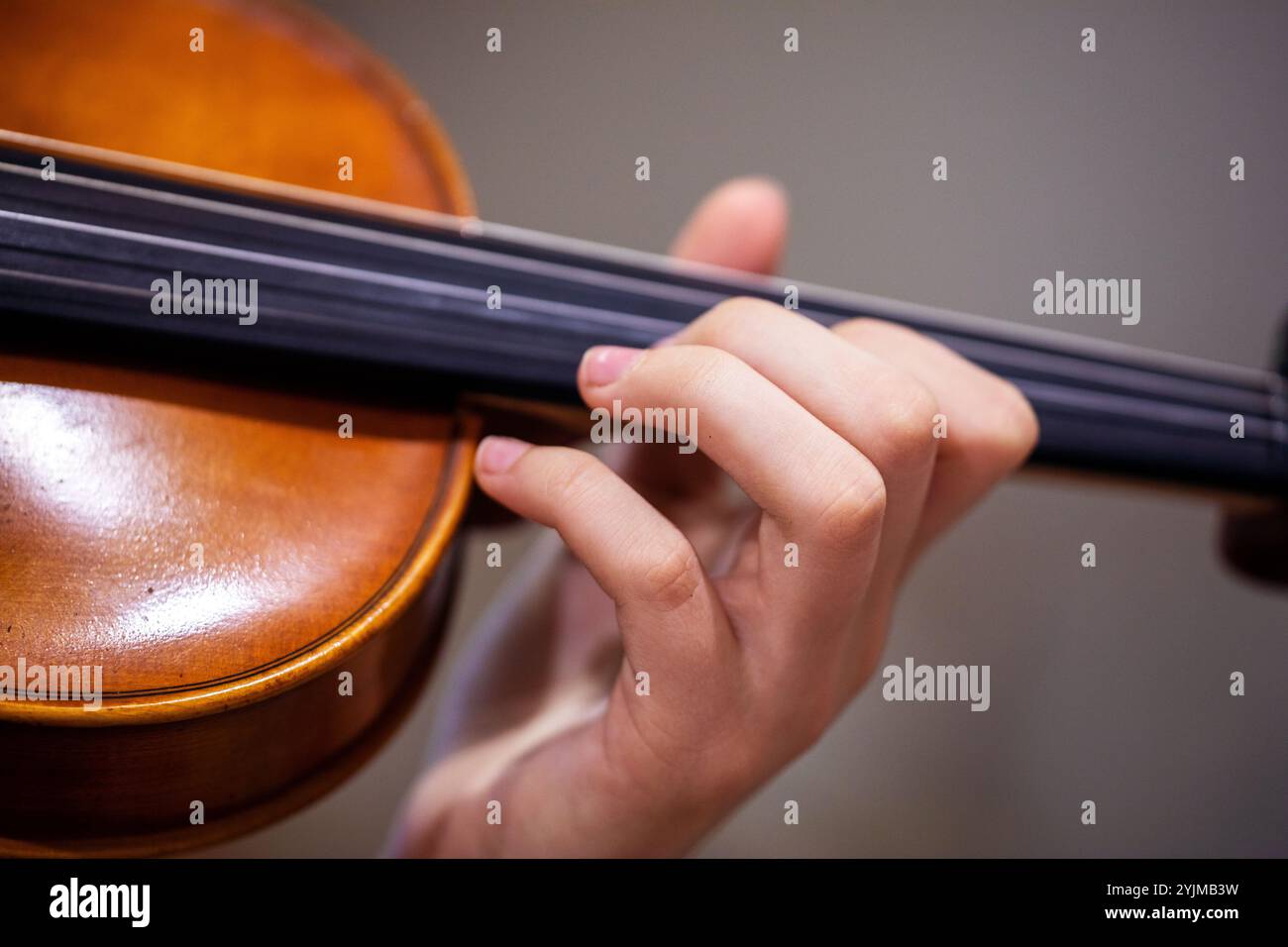 Spielen Sie mit der linken Hand Geige. Korrekte Positionierung von Hand und Fingern auf einem Musikinstrument Stockfoto