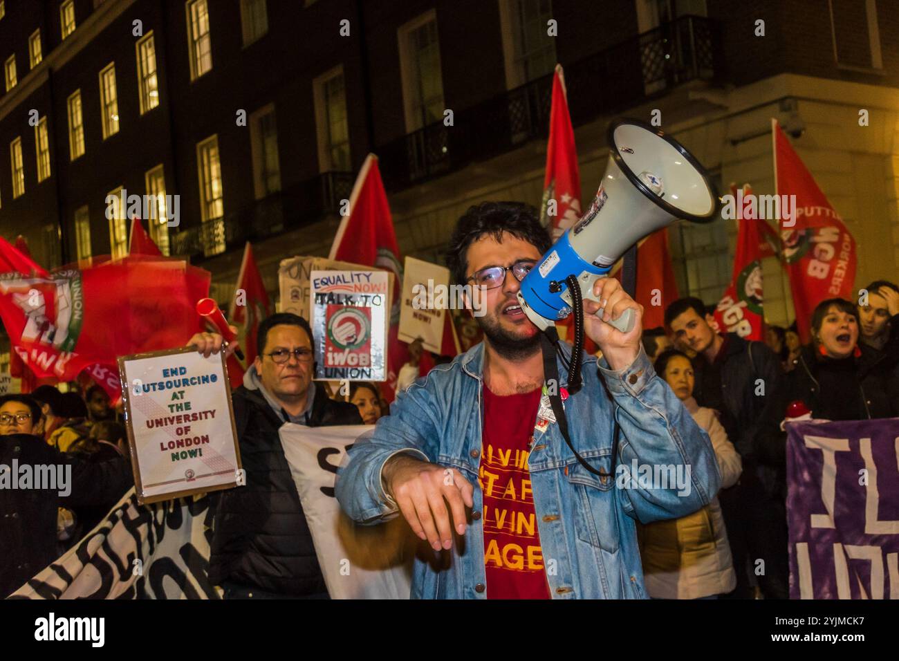 London, Großbritannien. November 2017. Ein Demonstrant hält eine Rauchfackel vor dem Banner "Jstice for UOL Workers" beim Protest der Independent Workers Union of Great Britain vor dem Senate House, während die Kanzlerin der Universität von London, Prinzessin Anne, am Foundation Day zu Besuch war und alle Arbeiter der Universität dazu aufrief, direkt von der Universität beschäftigt zu werden. Sie sagen, dass der Einsatz externer Auftragnehmer zur Einstellung von Personal diskriminierend sei, da ausgelagerte Arbeitnehmer, einschließlich Personal in den Bereichen Sicherheit, Reinigung und Gastronomie, die überwiegend Migranten sind, und BME-Arbeitnehmer zu weitaus schlechteren Bedingungen als Mitarbeiter seien Stockfoto