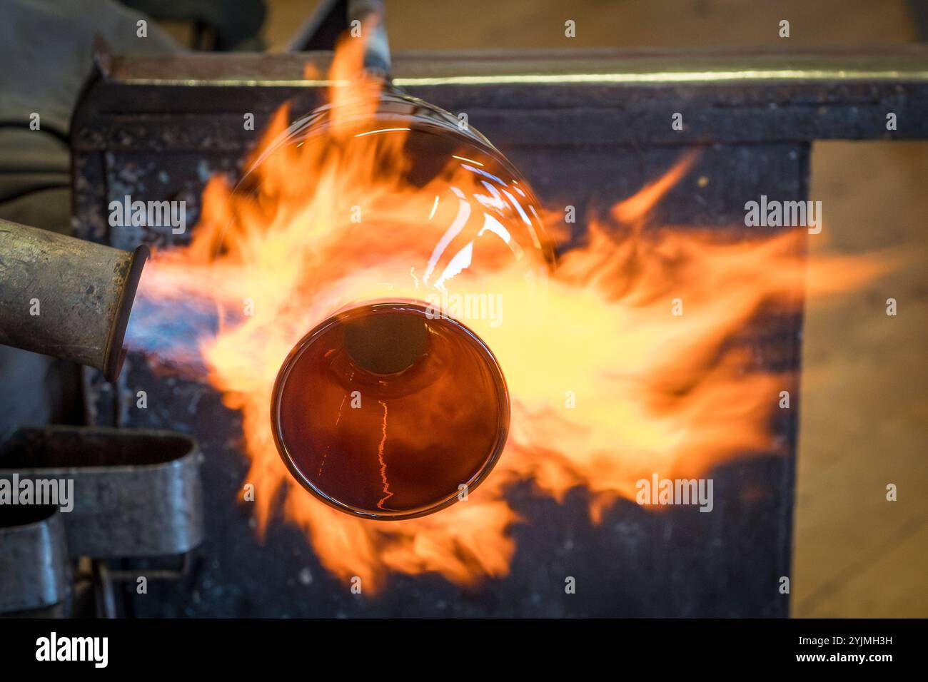 Glasbläserei – Arbeiten mit einem Brenner an einer mundgeblasenen Glasvase (GB) Stockfoto