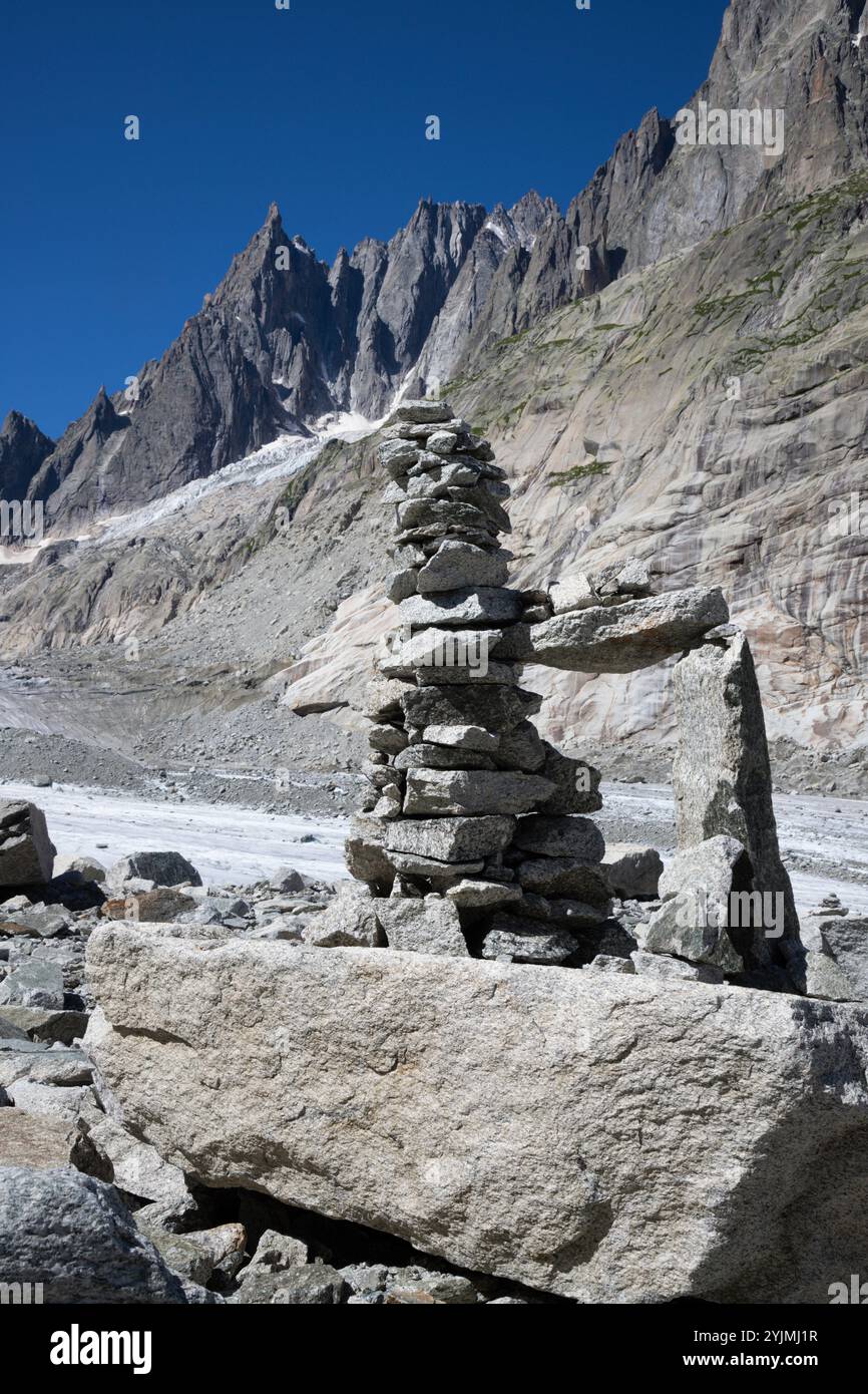 Der Gletscherbach auf dem Gletscher Mer de Glace mit den Aigulles-Türmen im Hintergrund. Stockfoto