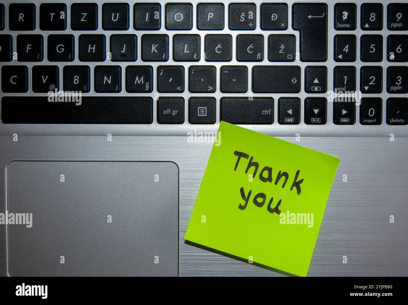 Ein konzeptionelles Foto einer grünen Haftnotiz mit einem handgeschriebenen „Dankeschön“-Zitat auf einer Laptop-Tastatur. Stockfoto